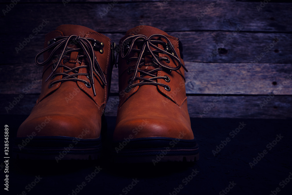 Brown, laced boots on an old wooden, rustic background. Brown, laced boots on an old wooden, rustic background.