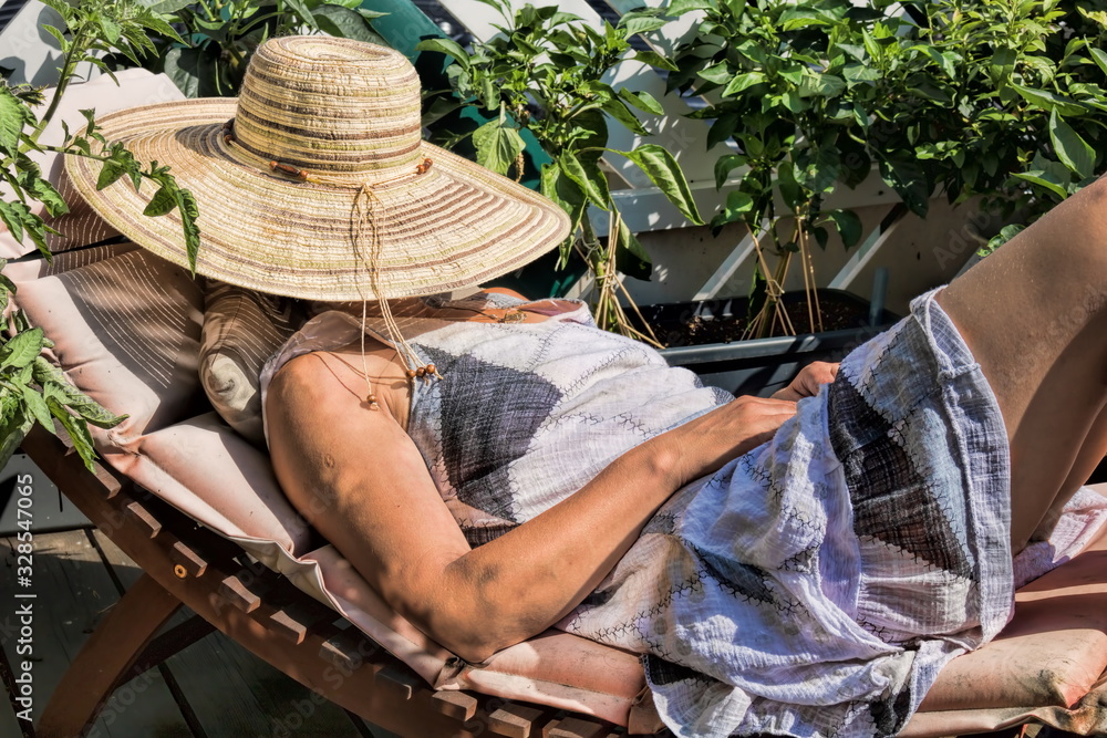 frau mit strohhut als sonnenschutz
