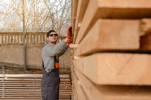 Lateral view of young man carpenter at the wooden warehouse © Med Photo Studio
