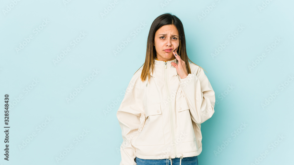 Young woman isolated on blue background having a strong teeth pain, molar ache. Young woman isolated on blue background having a strong teeth pain, molar ache.
