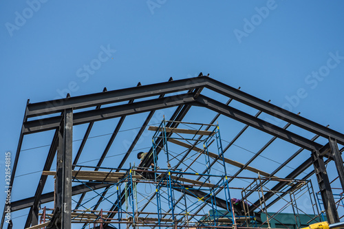 Worker installing structure of roof steel for new house
