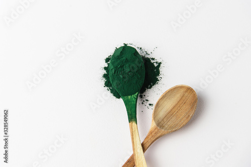 Wooden spoons with spirulina powder, superfood on a white background, green algae powder, smoothie, drink, healthy eating photo