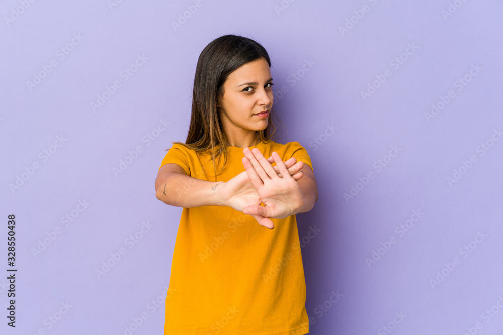 Young woman isolated on purple background standing with outstretched hand showing stop sign, preventing you. Young woman isolated on purple background standing with outstretched hand showing stop sign, preventing you.