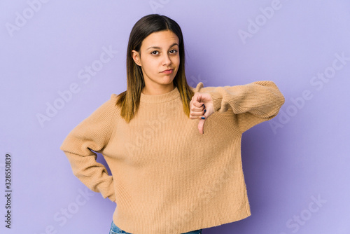 Young woman isolated on purple background showing thumb down, disappointment concept.