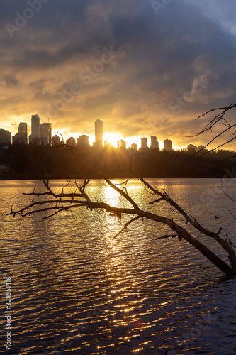 Burnaby, Greater Vancouver, British Columbia, Canada. Beautiful View of Deer Lake during a colorful and vibrant winter sunset with Metrotown Buildings in the Background. photo