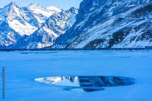 Winter landscape with snow covered peaks and frozen lake on Kleine Scheidegg mountain in Swiss Alps in Grindelwald ski resort  Switzerland