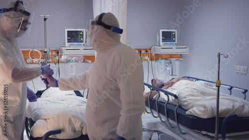 Doctor Measuring Coronavirus Patient's Temperature and Noting it Down - Wide Shot in Slow Motion
