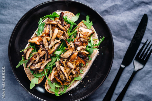 Top view of two vegan sandwiches with fresh arugula, fried shiitake mushroom and shallot onion.