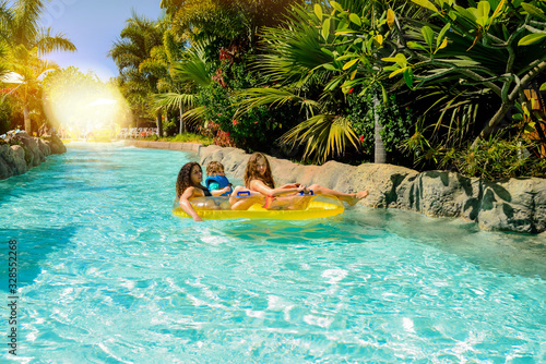 beautiful young girls and her mom sliding on a water slide photo