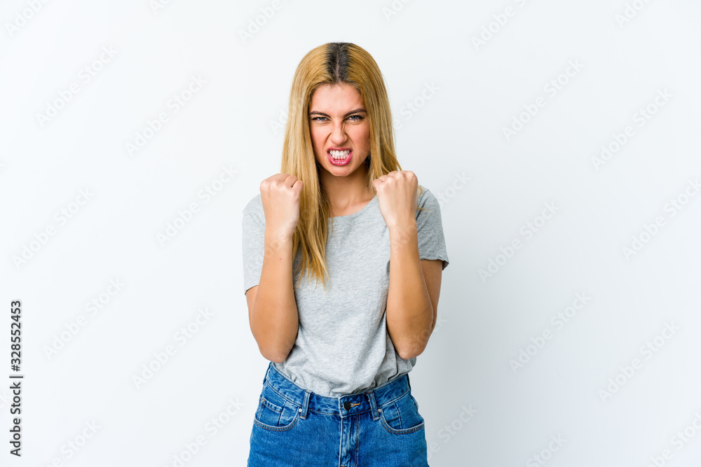 Young blonde woman isolated on white background upset screaming with tense hands. Young blonde woman isolated on white background upset screaming with tense hands.