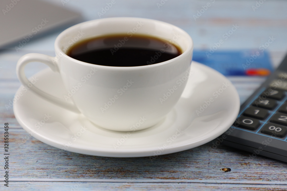 Obraz premium cup of coffee, credit card and calculator on the table in the office, business and finance concept