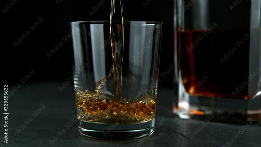Super Slow Motion Shot of Pouring Whiskey into Glass at 1000fps with Camera Movement. Super Slow Motion Shot of Pouring Whiskey into Glass at 1000fps with Camera Movement.