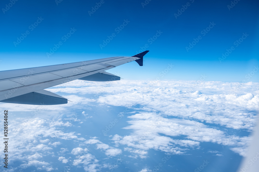 View from airplane window with blue sky and white clouds View from airplane window with blue sky and white clouds