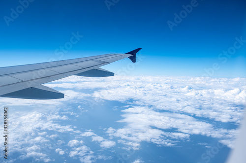 View from airplane window with blue sky and white clouds