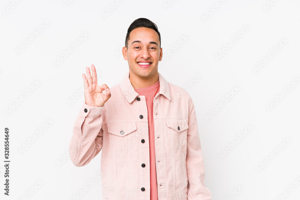 Young latin man posing isolated cheerful and confident showing ok gesture. Young latin man posing isolated cheerful and confident showing ok gesture.
