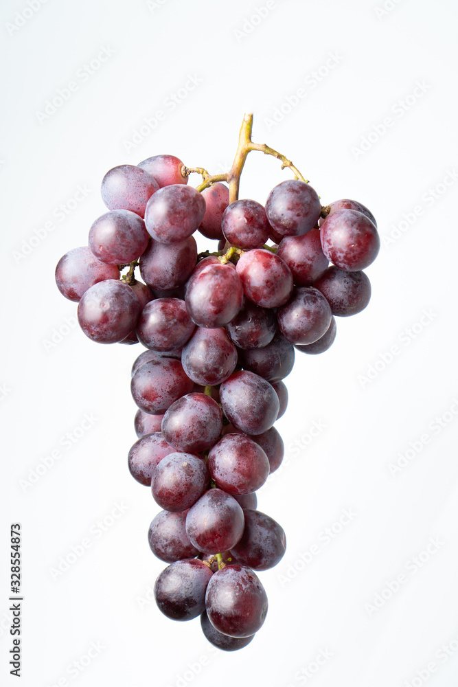 Purple grapes on a chopping block White background