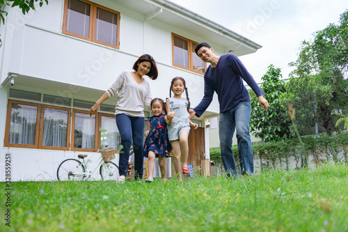 Happy and loverly asian family play on yard or garden in front of home, out door