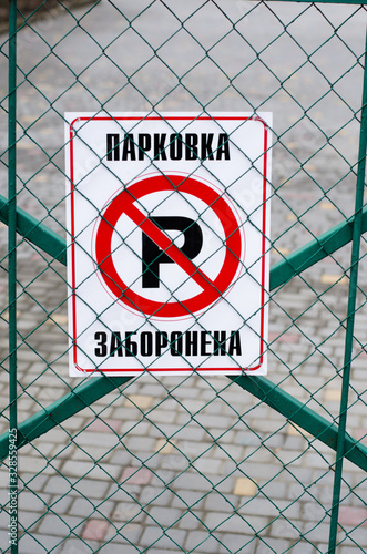 It is written in Ukrainian: "parking is prohibited." The road sign is attached to the gate.