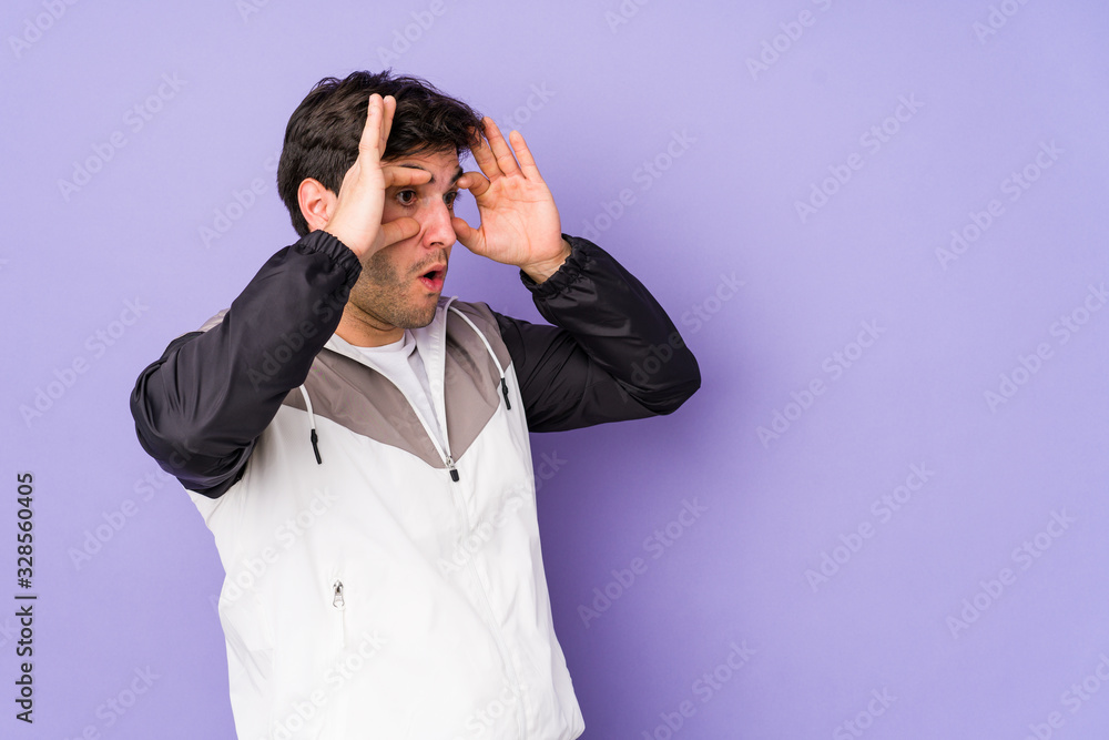 Young man isolated on purple background keeping eyes opened to find a success opportunity. Young man isolated on purple background keeping eyes opened to find a success opportunity.