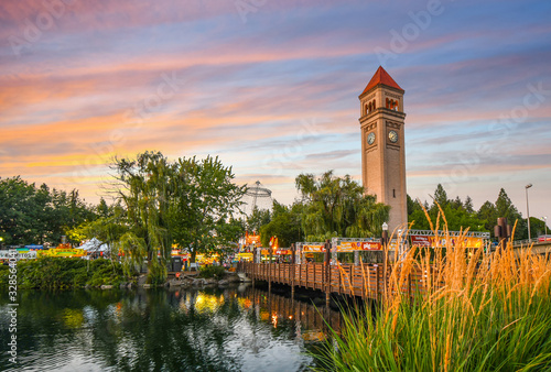 Festival goers enjoy a colorful sunset at the annual Pig out in the Park at Riverfront Park along the Spokane River in Spokane, Washington