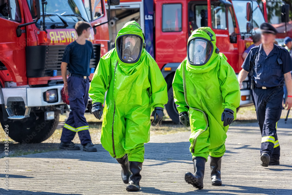 Two firefighters in protective suit for hazardous material during a