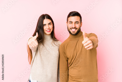 Young caucasian couple isolated with thumbs ups, cheers about something, support and respect concept.