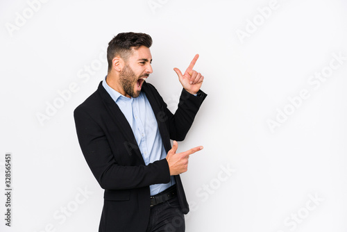 Young caucasian business man against a white background isolated pointing with forefingers to a copy space, expressing excitement and desire.