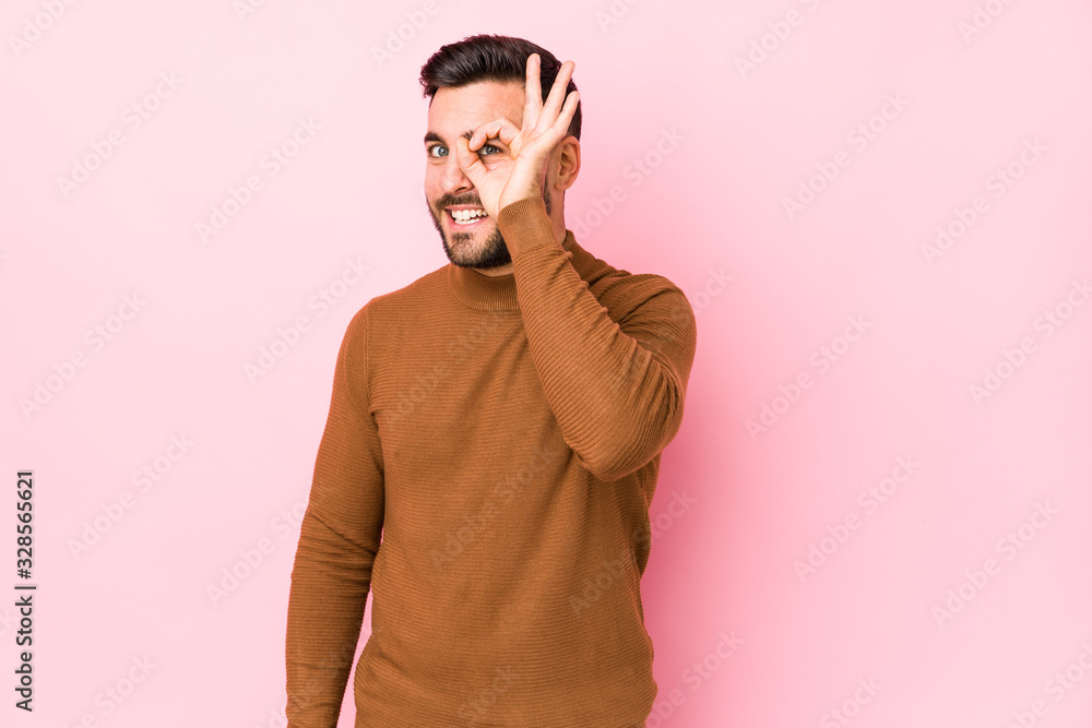 Young caucasian man against a pink background isolated excited keeping ok gesture on eye. Young caucasian man against a pink background isolated excited keeping ok gesture on eye.