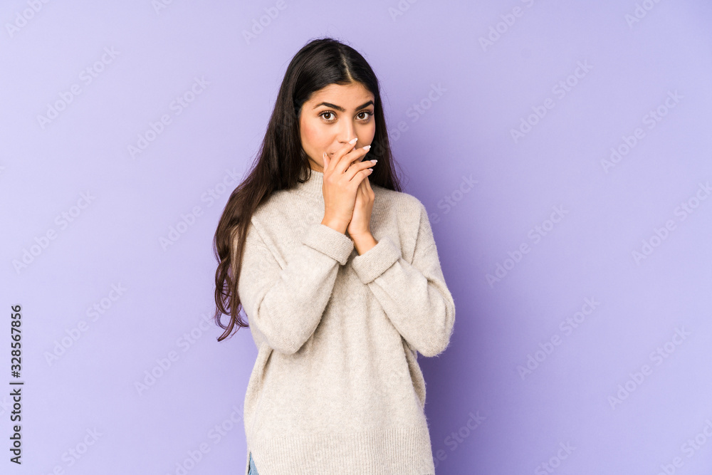 Young indian woman isolated on purple background covering mouth with hands looking worried. Young indian woman isolated on purple background covering mouth with hands looking worried.