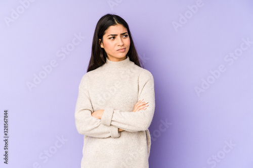 Young indian woman isolated on purple background unhappy looking in camera with sarcastic expression.