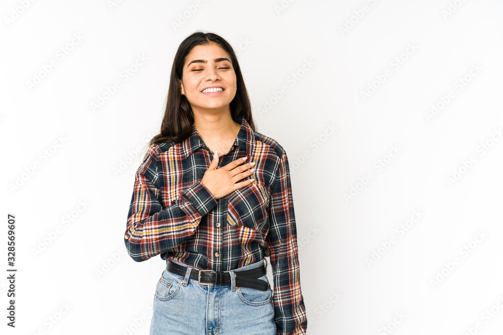 Young indian woman isolated on purple background laughs out loudly keeping hand on chest. Young indian woman isolated on purple background laughs out loudly keeping hand on chest.