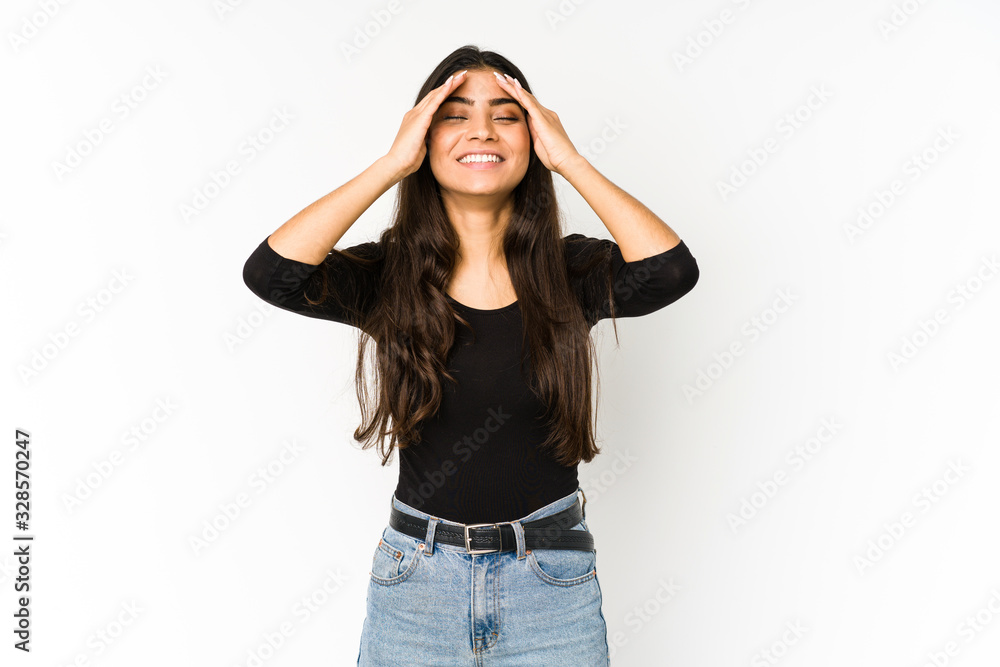 Young indian woman isolated on purple background laughs joyfully keeping hands on head. Happiness concept. Young indian woman isolated on purple background laughs joyfully keeping hands on head. Happiness concept.
