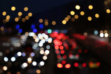 Blurred lights of car headlights and lanterns on the night street. Traffic jam on a city road, transport, colorful abstract background