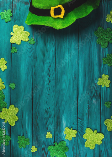 St Patrick Day dark green wooden rustic background with shamrock and leprechaun costume hat