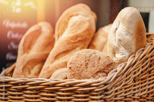 Fresh bread baguette Italy in wicker basket on counter, sunlight