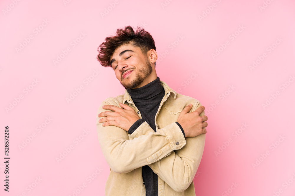 Young arabian man posing in a background isolated hugs, smiling carefree and happy. Young arabian man posing in a background isolated hugs, smiling carefree and happy.