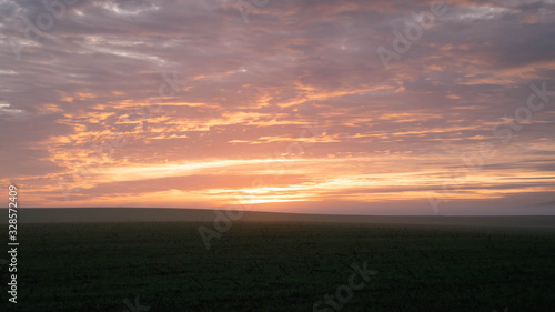 Countryside sunset landscape with agricultural fields. Beautiful orange clouds © TMC