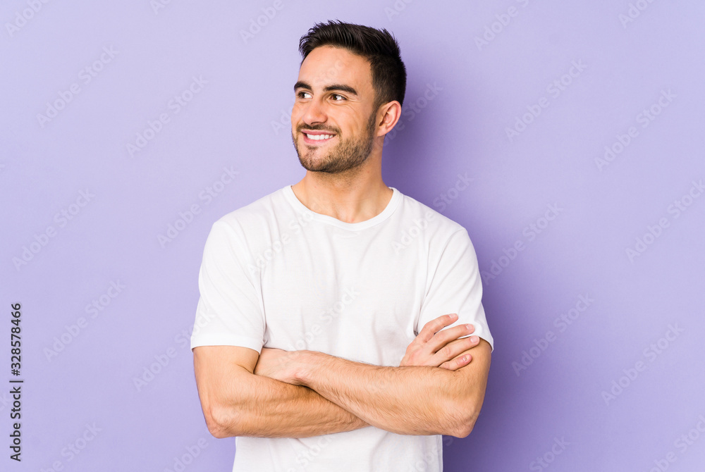 Fototapeta premium Young caucasian man isolated on purple background smiling confident with crossed arms.