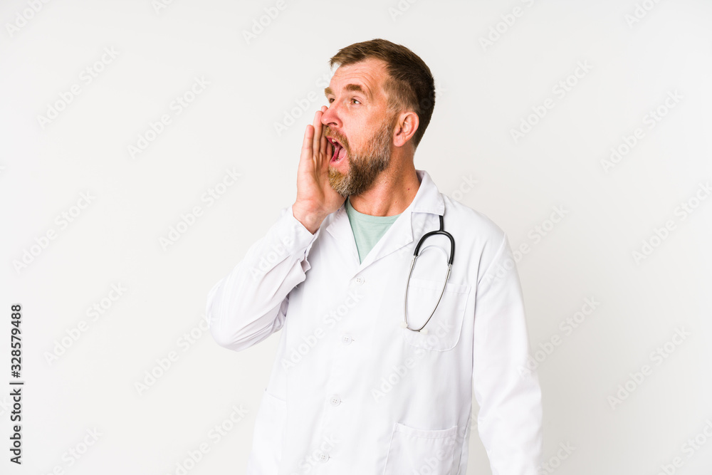 Senior doctor man isolated on white background shouting and holding palm near opened mouth. Senior doctor man isolated on white background shouting and holding palm near opened mouth.