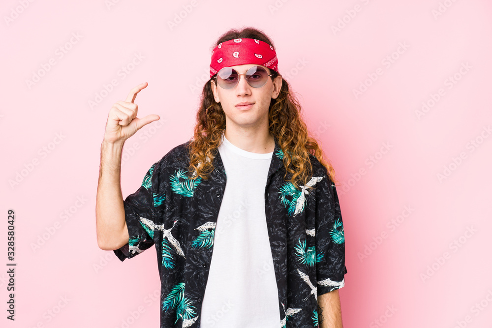 Young hippie caucasian man isolated holding something little with forefingers, smiling and confident. Young hippie caucasian man isolated holding something little with forefingers, smiling and confident.