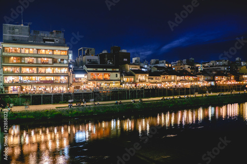 Traditional restaurants and Kamo River reflections at night, Kyoto, Japan © Samuel Ponce