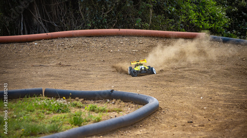 Yellow electric RC buggy drifting through a corner on an offroad outdoor track