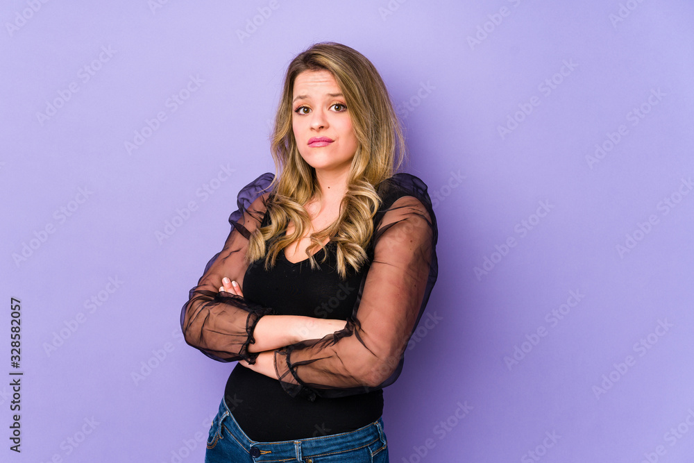 Young caucasian woman isolated on purple background suspicious, uncertain, examining you. Young caucasian woman isolated on purple background suspicious, uncertain, examining you.