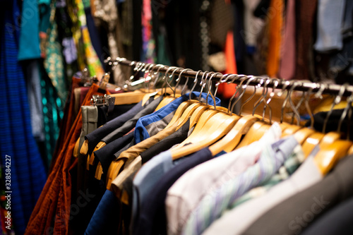 Different clothes on the stand. Fashion swap, second hand, slow fashion. Close up on used clothes. 