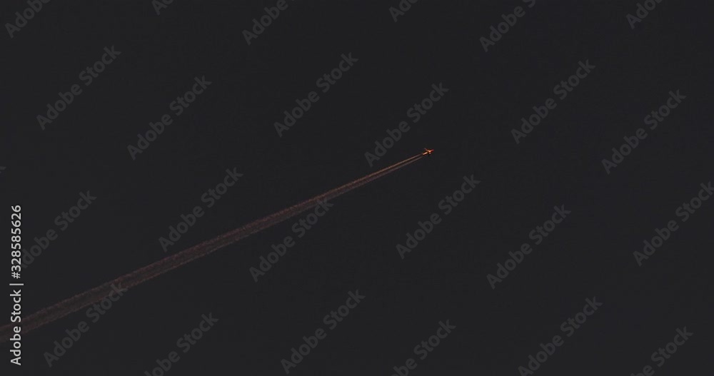 Airplane and vapour trails (contrails) crossing the sky at sunset, golden hour. Flying diagonal from left to right. Airplane and vapour trails (contrails) crossing the sky at sunset, golden hour. Flying diagonal from left to right.