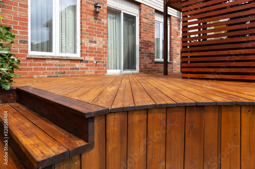 Backyard wooden deck floor boards with fresh brown stain