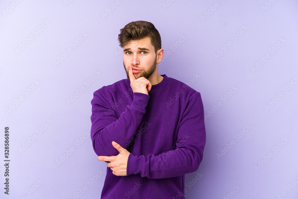 Young caucasian man isolated on purple background looking sideways with doubtful and skeptical expression. Young caucasian man isolated on purple background looking sideways with doubtful and skeptical expression.