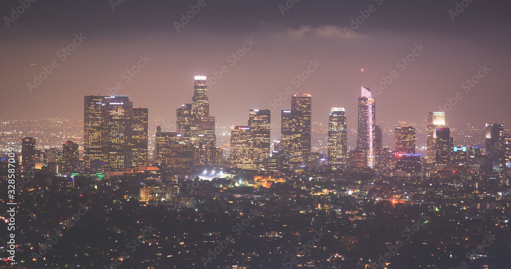 Beautiful super wide-angle night aerial view of Los Angeles, California, USA, with downtown district, mountains and scenery beyond the city, seen from the observation deck of Griffith Park observatory