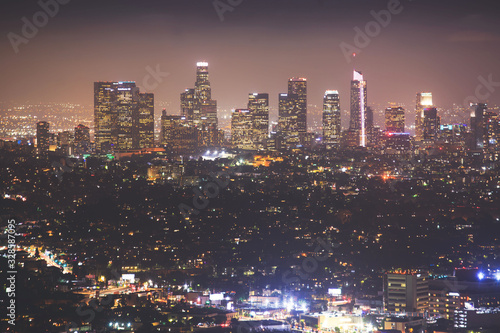 Beautiful super wide-angle night aerial view of Los Angeles, California, USA, with downtown district, mountains and scenery beyond the city, seen from the observation deck of Griffith Park observatory © tsuguliev