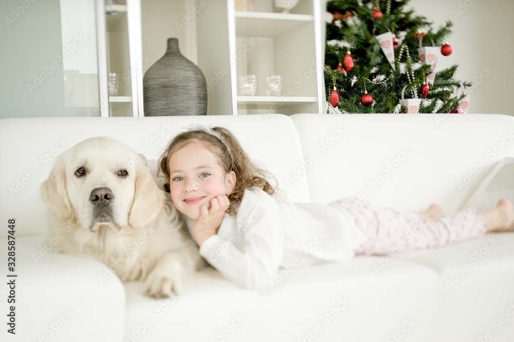 Cute little child with golden retriever dog enjoying Christmas atmosphere Cute little child with golden retriever dog enjoying Christmas atmosphere